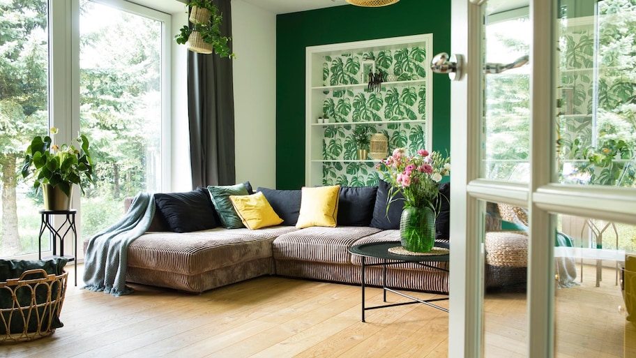 A modern living room with large windows and nature views