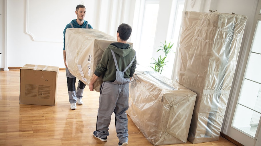 Professional movers moving furniture in to a living room