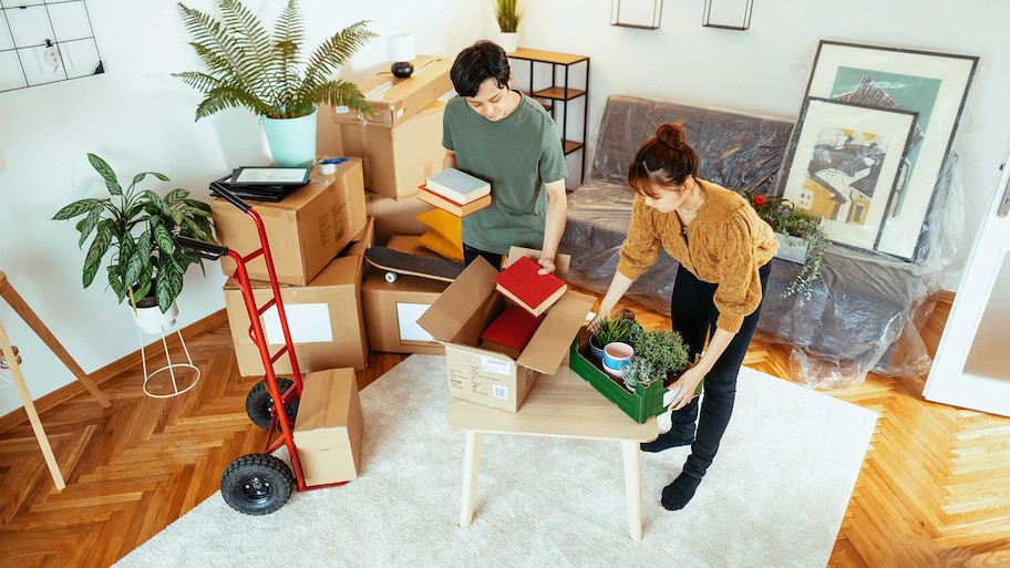 Couple in their apartment packing boxes