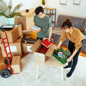 Couple in their apartment packing boxes