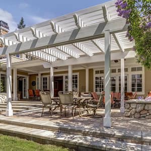 A patio with dining area under a white pergola