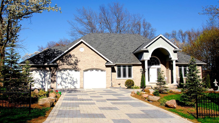 A paved driveway leading to a closed double door garage