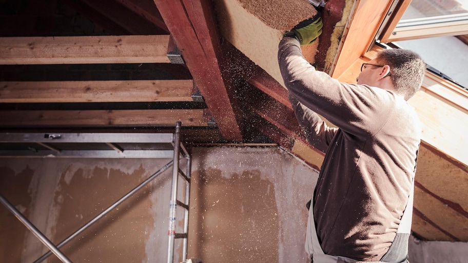 A professional insulating a house’s attic