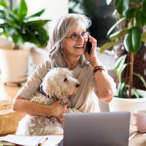 A woman with her dog at the table in home office