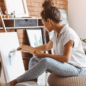 Woman painting easel floor pillow