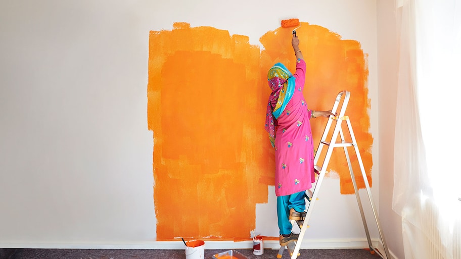 Woman painting wall orange