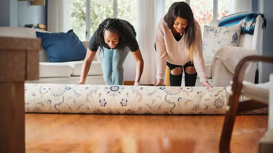 Women unrolling rug