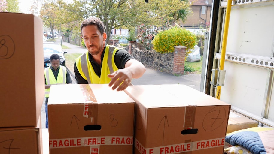 A worker unloading boxes from van