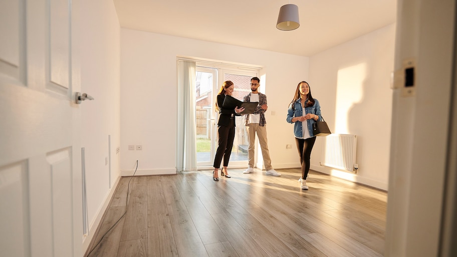 A young couple with a real estate agent checking a new house