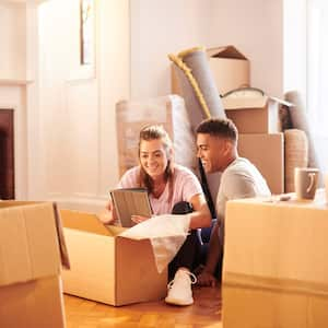 A young couple packing moving boxes