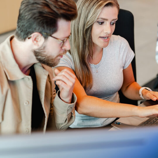 Co-workers looking at a laptop