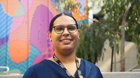  Image of a RMIT worker standing in front of a coloured wall.