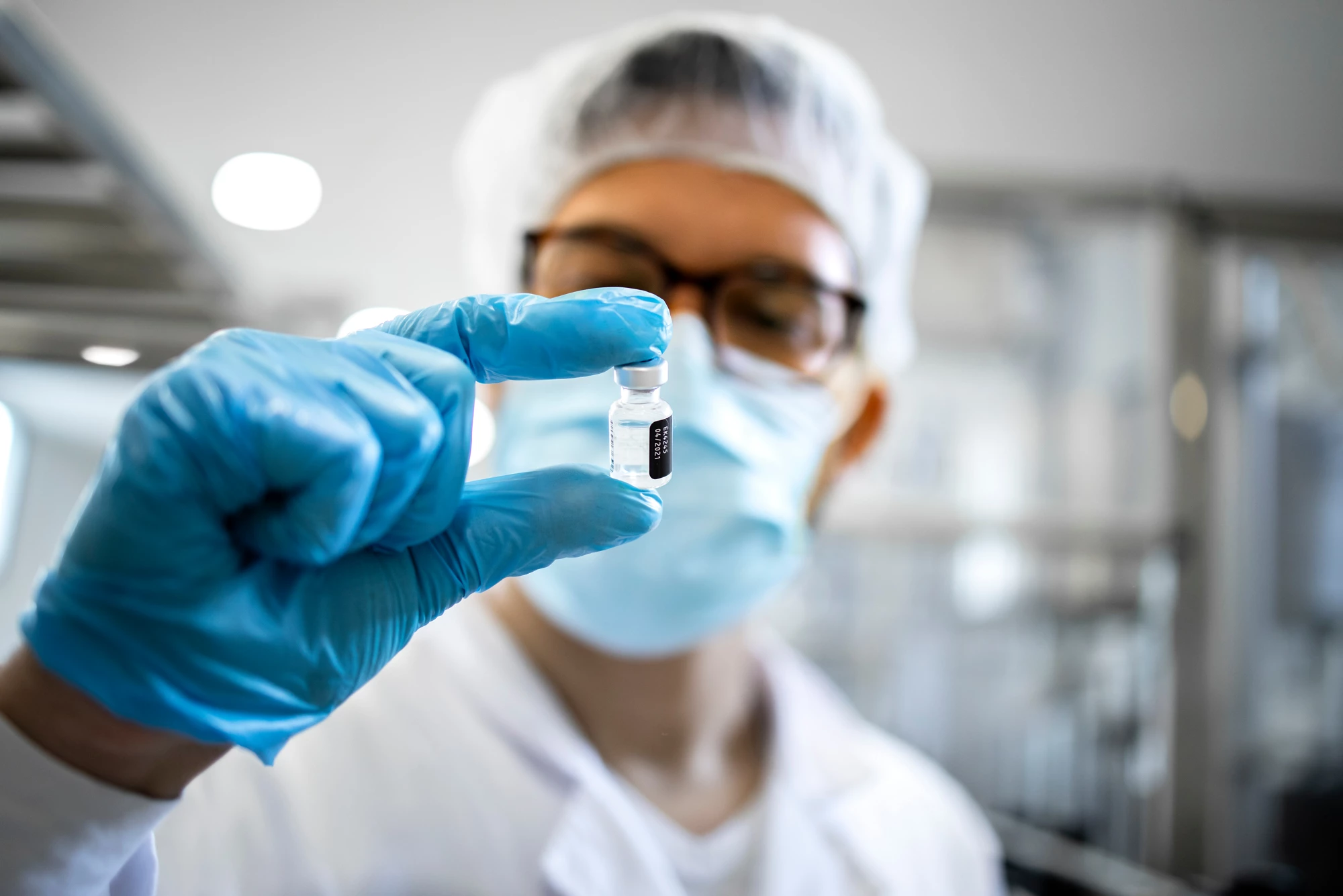 A doctor holding a vial of vaccine.