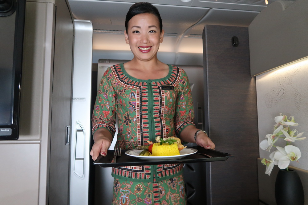 a woman holding a tray with food on it