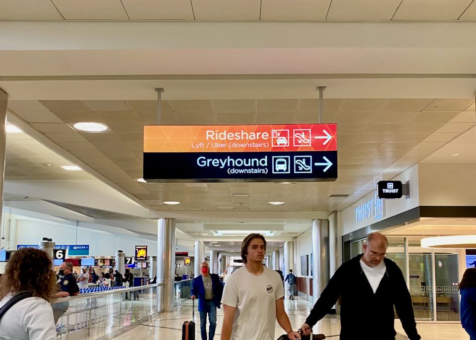 Signs hanging from the ceiling have arrows pointing to the right stating, "Rideshare" this way.