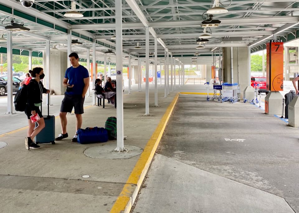 A man and woman wait in the Rideshare lot.