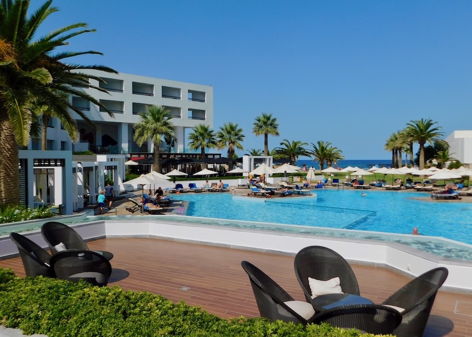 A sea-facing infinity pool with a kids' section next to a contemporary building at Creta Palace resort in Crete