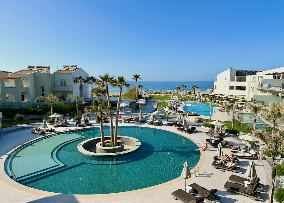 A circular pool and a freeform pool behind the beach at Nautilux resort in Crete