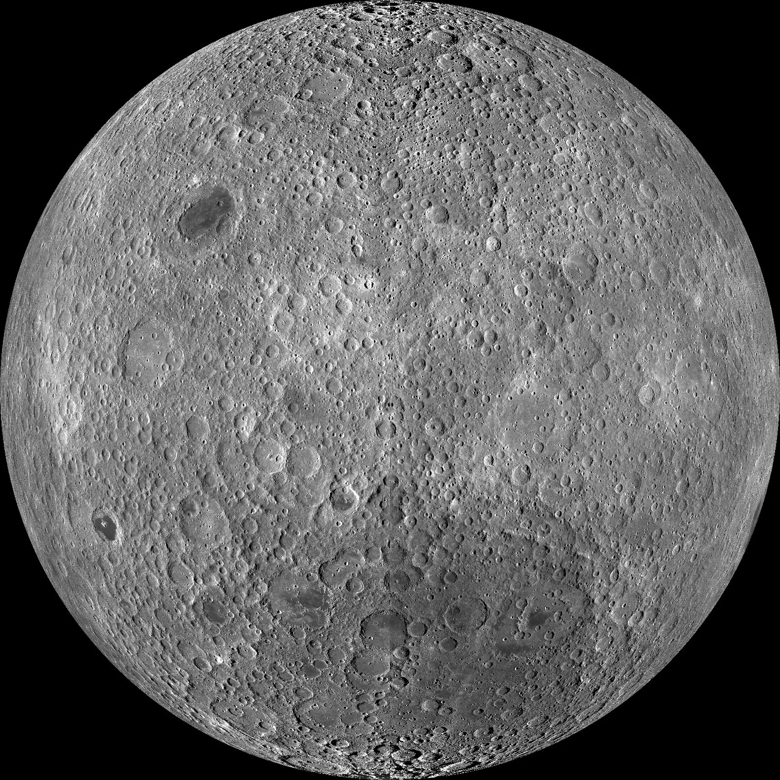 Many little impact craters litter the far side of the moon. In the upper left quadrant lies a darker crater that contrasts a lot of the light grey color surrounding it. It is a stand alone dark grey crater encircled by many smaller lighter craters. In the southern part of the far side of the moon, almost a quarter of it, has a darker splotch that has smaller impact craters layered on top.