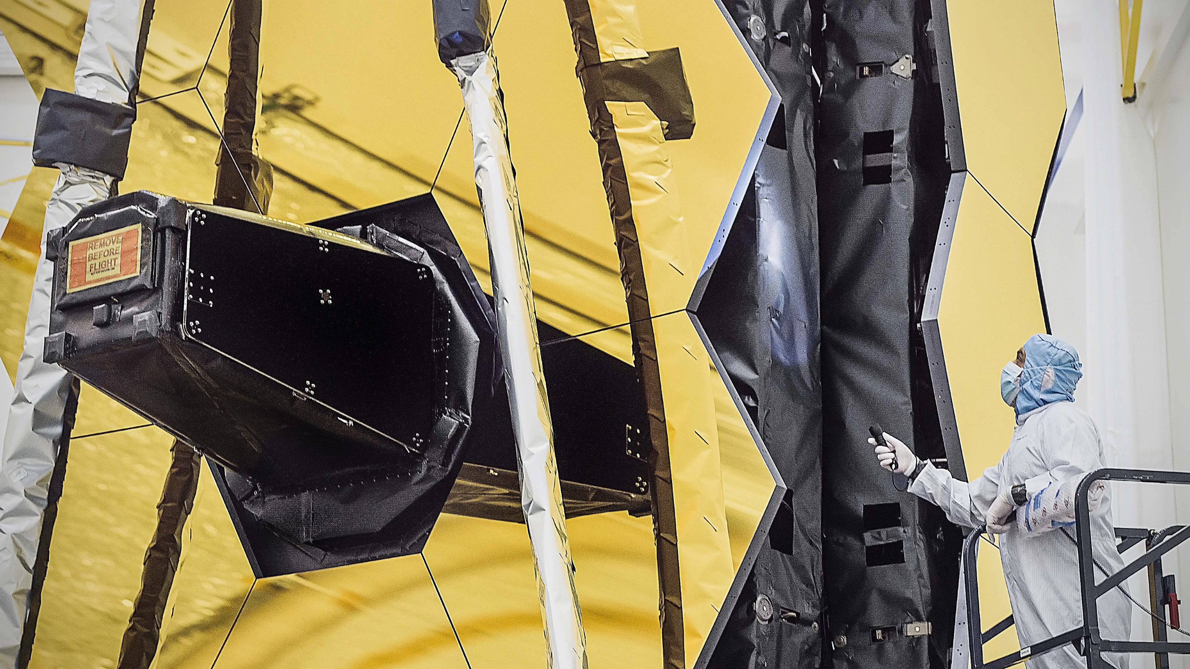 An engineer looks over he James Webb Space Telescope