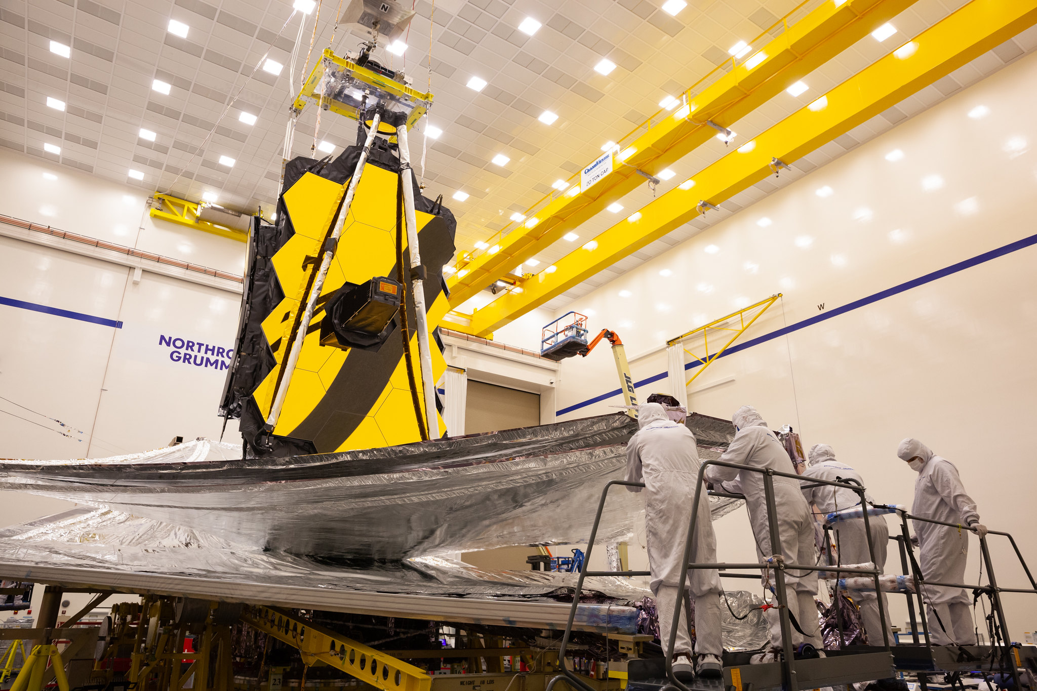 Webb in the Northrup Grumman clean room for final integration and test before launch. Technicians preparing the sunshield for folding after a successful deployment test.