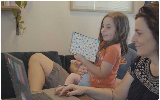 Picture of a mother and daughter on a Skype call with granddad.