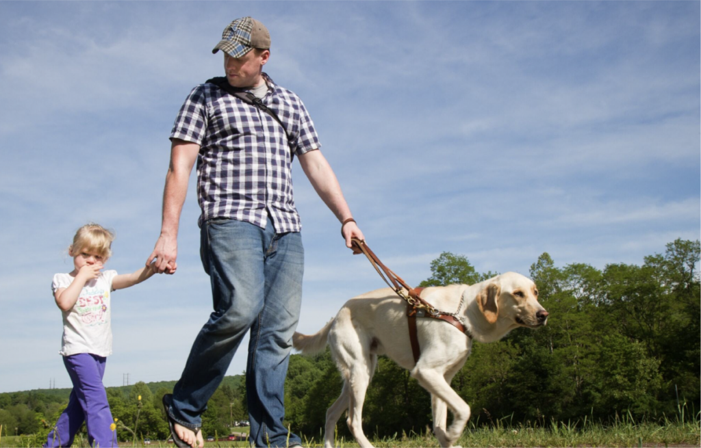 Father, daughter, and dog holding hands and walking