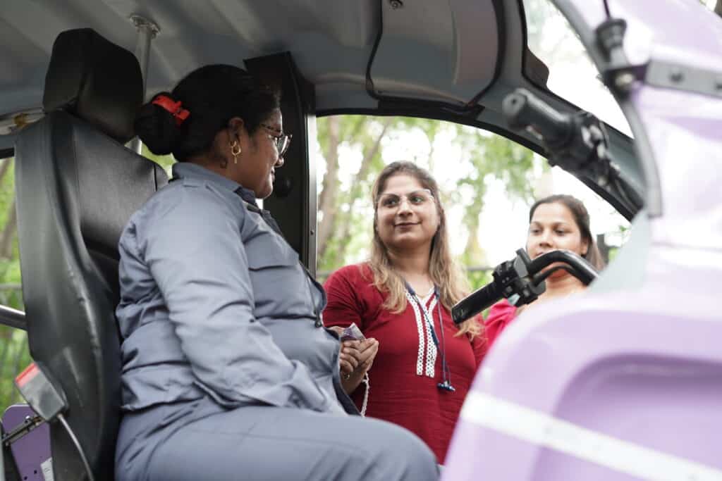 Woman rickshaw receiving money from customers