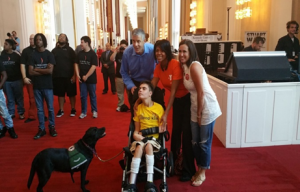 Secretary Duncan and friends posing with a boy in a wheelchair and his assistant dog.