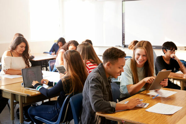 scholieren in een klas aan het samenwerken achter laptop