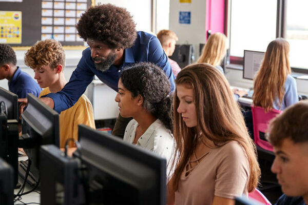 kinderen in computerlokaal krijgen uitleg van docent