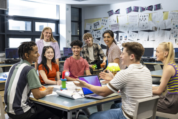 blije studenten lachen samen en kijken op computerscherm