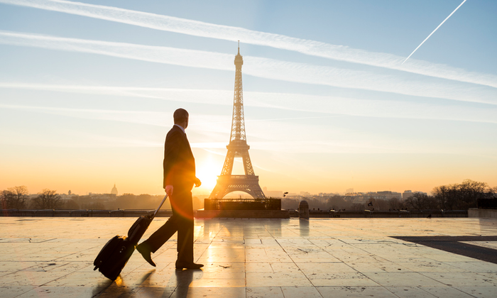 Travel businessman walking with suitcase at Eiffel Tower in Paris