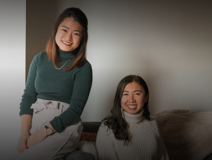 In this image, two women are getting their pictures taken with smiling faces.