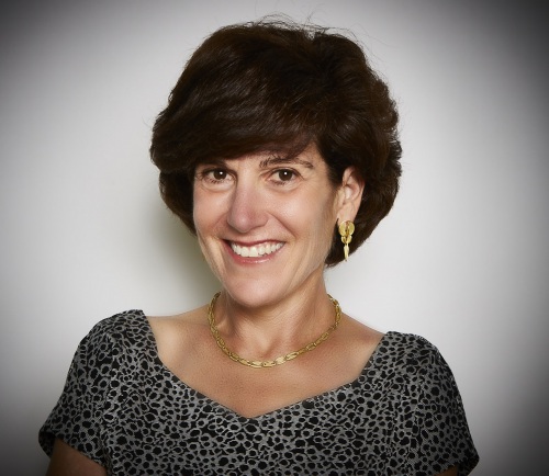 Headshot of Laura Lauder wearing fisheye blouse and gold necklace.