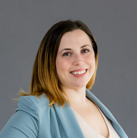 A smiling woman in a blue blazer.