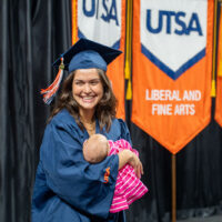 Mariana Rezende Tigre Cheatham smiles as she holds her baby on the Commencement stage