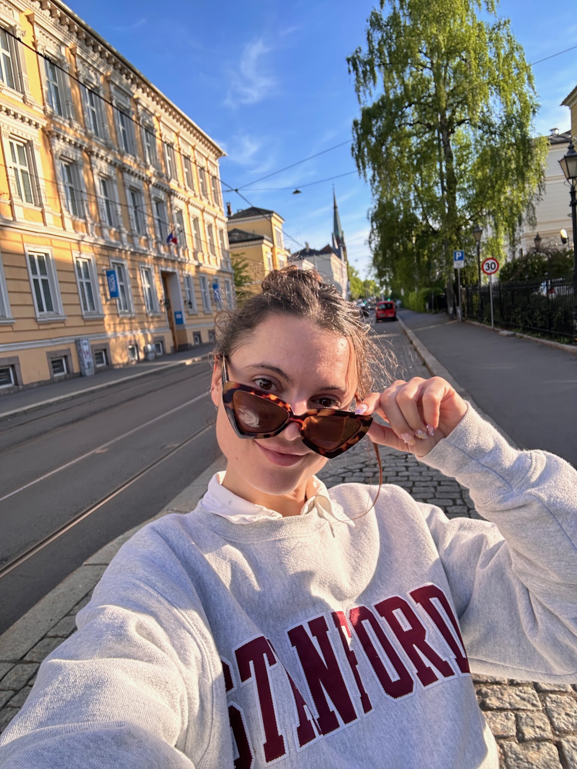 a woman taking a selfie on a charming street of Oslo