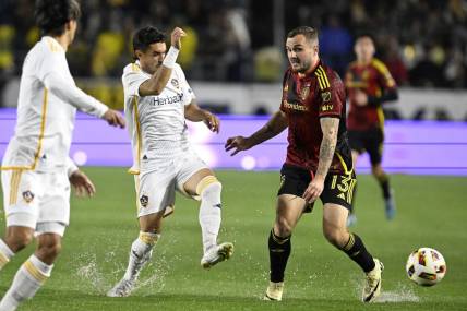 Mar 30, 2024; Carson, California, USA; LA Galaxy midfielder Gaston Brugman (5) battles for the ball against Seattle Sounders FC forward Jordan Morris (13) during the first half at Dignity Health Sports Park. Mandatory Credit: Alex Gallardo-USA TODAY Sports