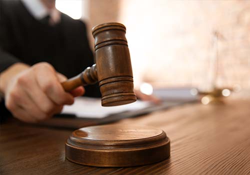 Judge With Gavel At Table In Courtroom