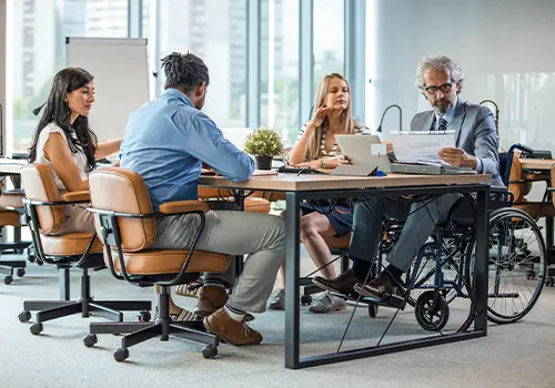 Disabled Man Sitting With Colleagues