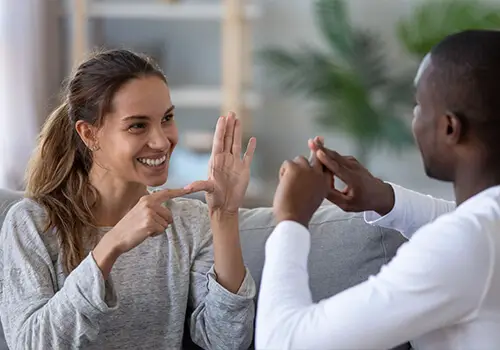 Two Friends Smiling While Using Sign Language