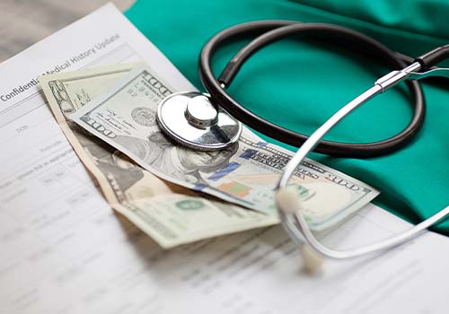 Dollars Next To Stethoscope Cost Of Medical Insurance