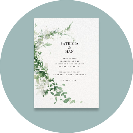 A white invitation with a leafy green accent on a light blue backdrop.