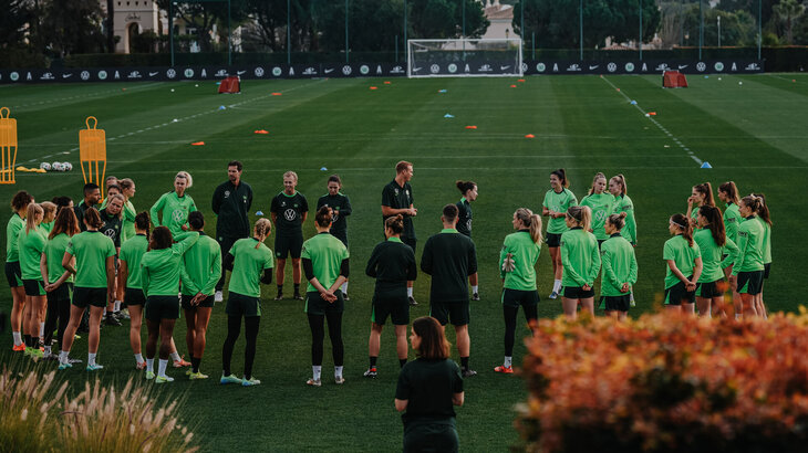 Die VfL-Wolfsburg-Spielerinnen stehen im Kreis auf dem Trainingsplatz.