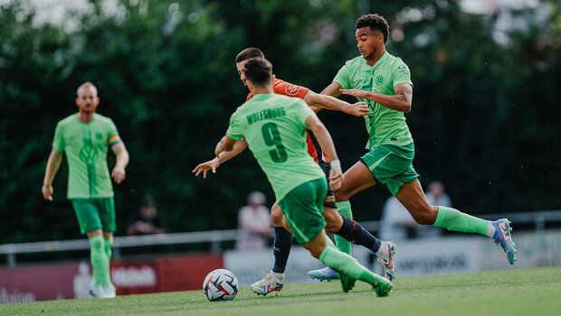 VfL Wolfsburg David Odogu attakiert im Testspiel gegen Lille OCS einen Gegner, sein Teamkollege kommt ihm zu Hilfe.