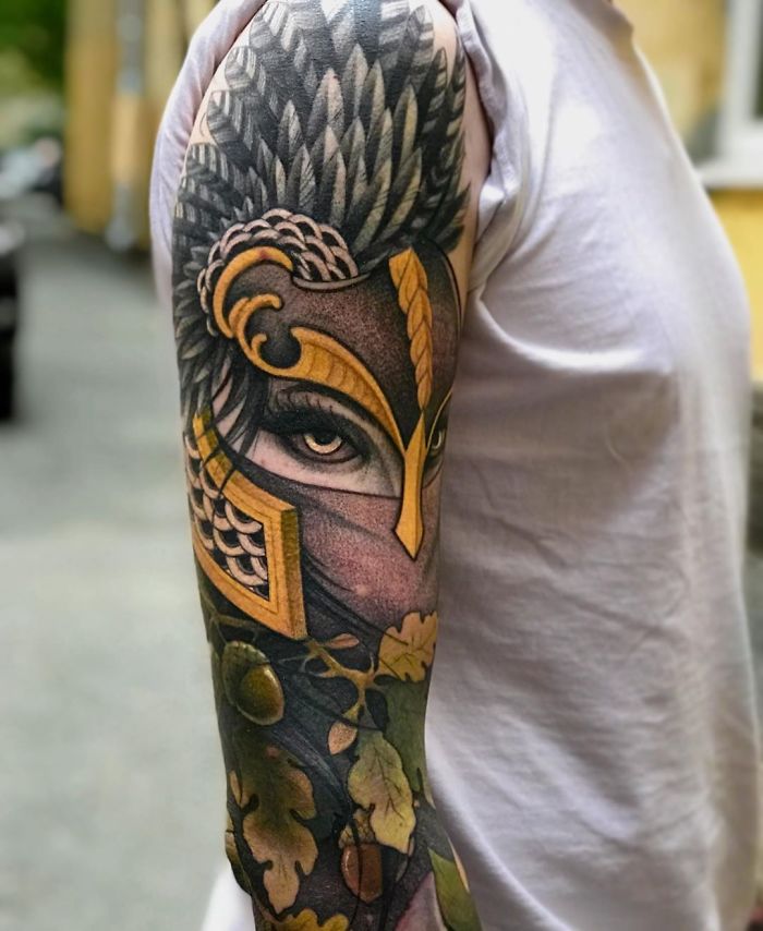 Arm sleeve with a detailed Viking tattoo featuring a warrior's face in a helmet, full of vibrant colors and intricate designs.