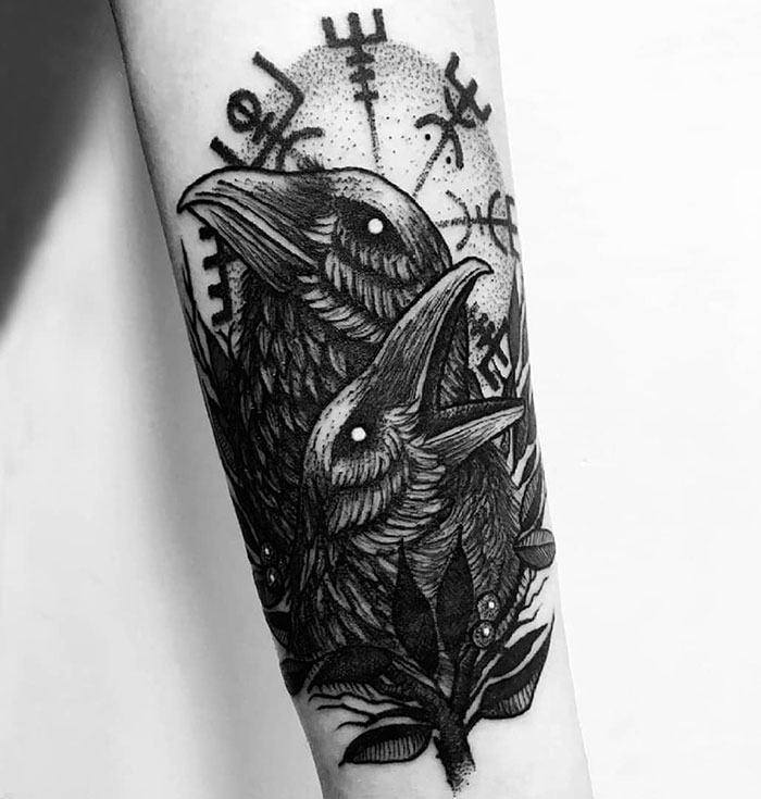 Raven Viking tattoo with runes on forearm, showcasing intricate Norse artwork.