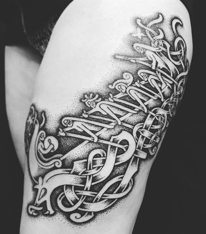 Intricate Viking tattoo design featuring knotwork and mythical elements on a forearm.