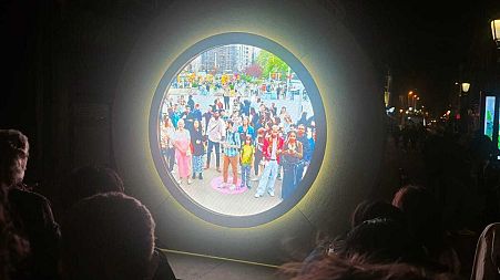 Excited Dubliners crowd around the portal at night time to get a glimpse of New Yorkers during the day.